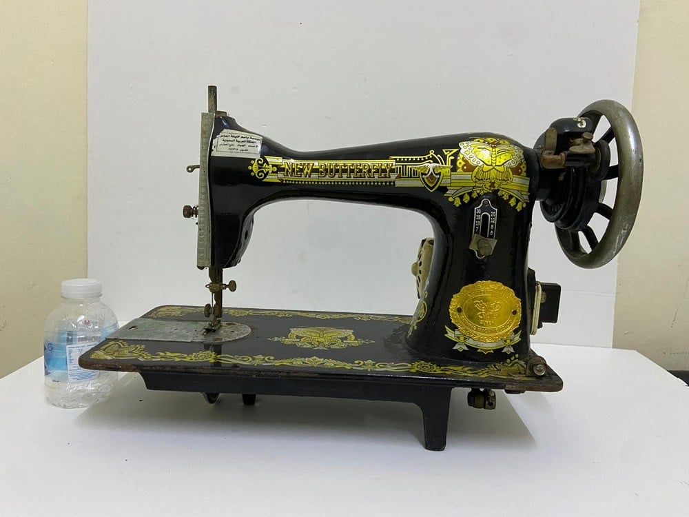 An old black sewing machine decorated with golden patterns - 1