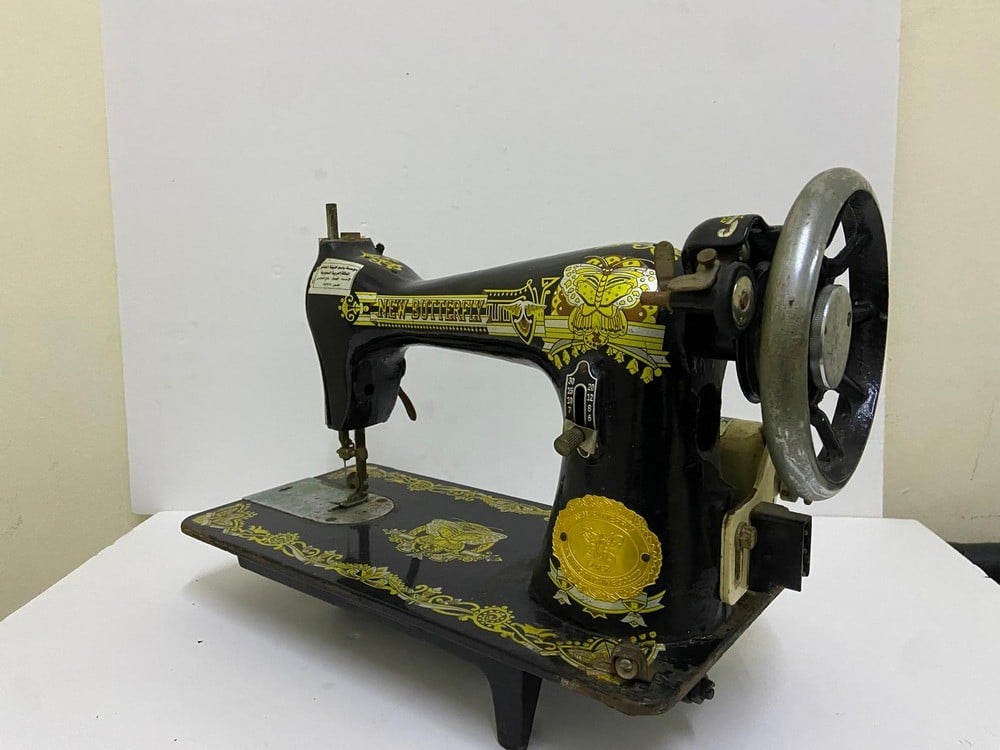 An old black sewing machine decorated with golden patterns - 2