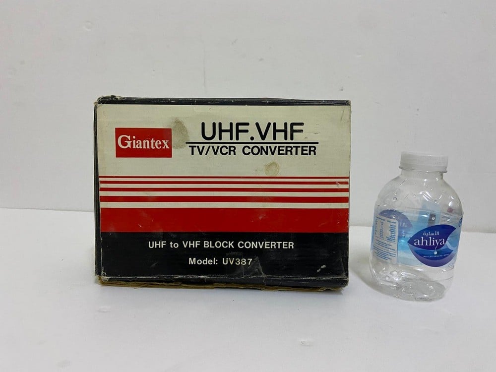 Old TV and channel converter (UHF to VHF TV/VCR Converter) by Giantex, model UV387, with its original box. - 2