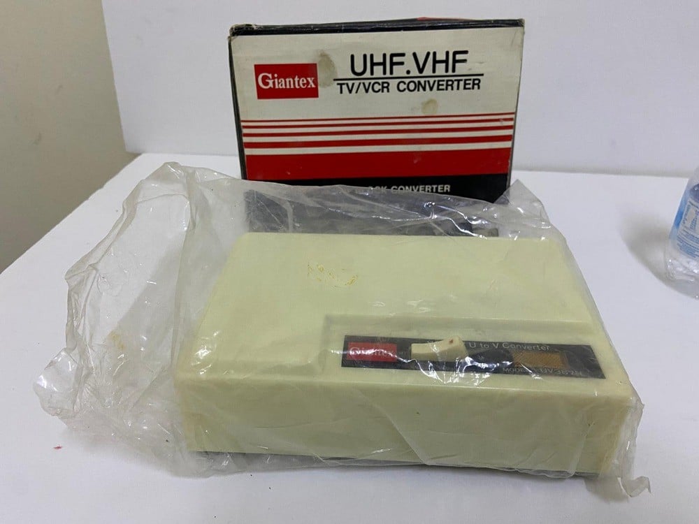 Old TV and channel converter (UHF to VHF TV/VCR Converter) by Giantex, model UV387, with its original box. - 1