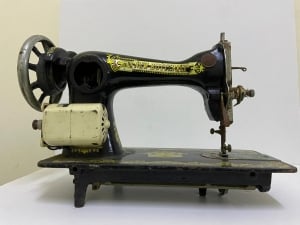 An old black sewing machine decorated with golden patterns - 4