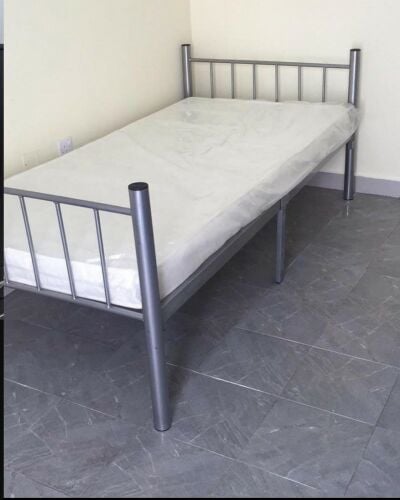 single metal bed with mattress.,